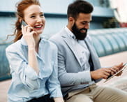 Un uomo e una donna in abiti eleganti mentre parlano al telefono